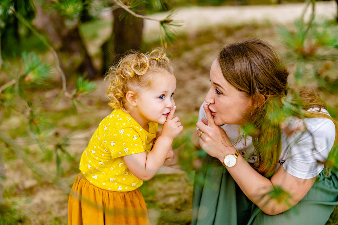Fotoshoot met moeder en dochter die spelenderwijs op de foto worden gezet in het bos